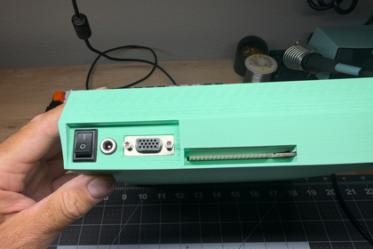 Mint green case rear panel showing power switch, audio jack, VGA port, and expansion connector
